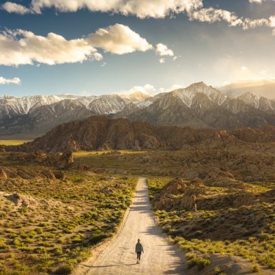 Lonely person walking on a pathway in Alabama hills in California with Mount Whitney in background