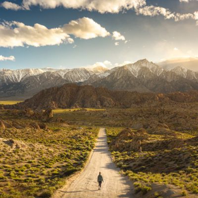 Lonely person walking on a pathway in Alabama hills in California with Mount Whitney in background
